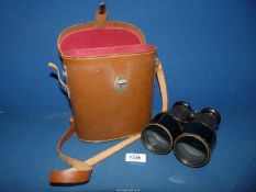 A cased pair of leather coated Binoculars.