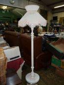 A Standard Lamp having a turned and fluted pillar and an elegant pleated white fabric shade with