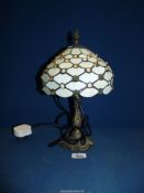 A Tiffany style table lamp with a cream jeweled glass shade, 13'' tall.