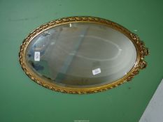 A pretty bevelled edge wall Mirror with gilt frame decorated with bow, roses and twisted design,