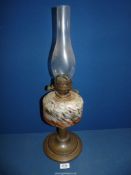 An Oil lamp with mottled colour glass reservoir and metal base.