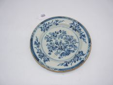 An 18th century English or Irish Delft plate painted flowers and with cafe au lait edge,