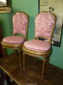 A pair of turned and carved giltwood framed side chairs standing on turned and fluted front legs