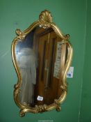 A shaped gilt framed wall Mirror having shell crest to the top, 17 1/4" x 28 1/2'' high overall.