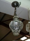 A clear blown glass celing light with wire surround.