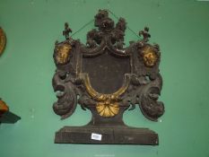 A carved giltwood frame the recess for a heraldic device flanked by scrolls and opposing
