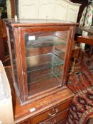A dark Oak cased confectionery cabinet glazed to three sides and having three glass shelves within.