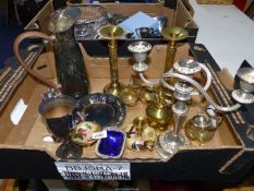 An EPNS water jug and goblet, small tray, two brass effect candle sticks,