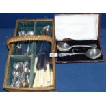 A cutlery basket and contents to include plated spoons, forks, knives etc.
