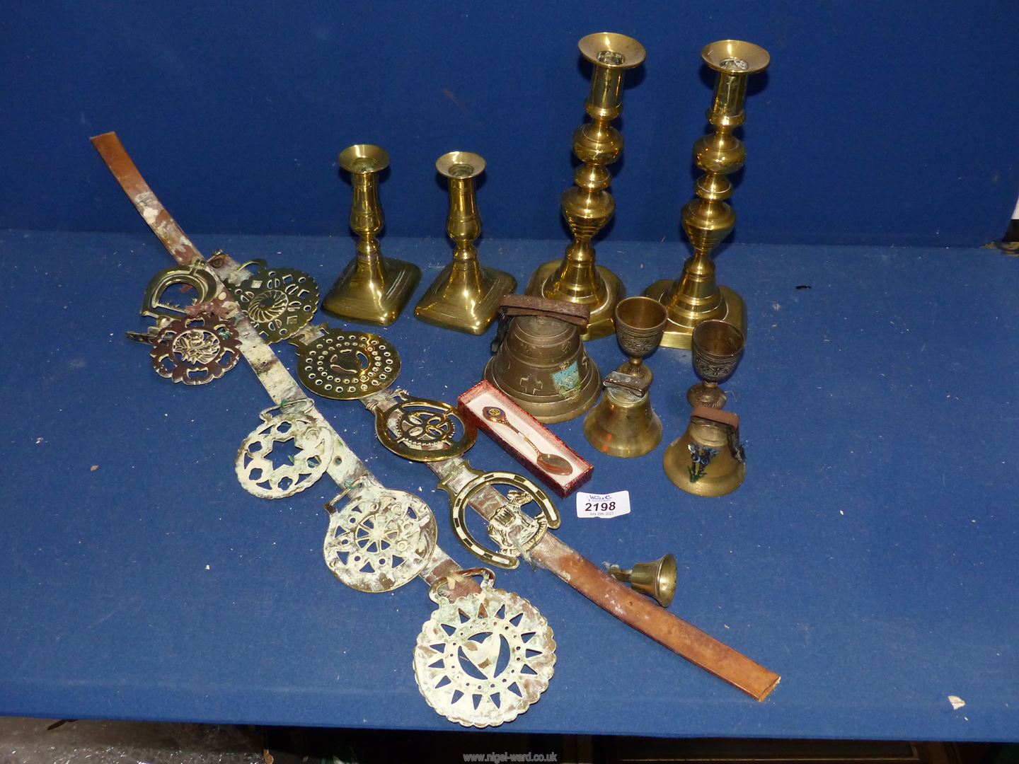 A quantity of brass including two pairs of candlesticks (one with pushers), horse brasses,