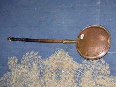 A copper warming pan decorated with flowers to lid, having wooden handle.