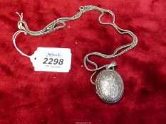 A Victorian silver Locket and Chain, the large locket having beautiful engraved decoration.