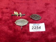 Three silver brooches including one with enamelled birds on a branch,
