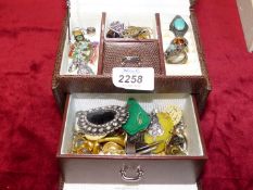 A brown jewellery case and contents of costume brooches, earrings, rings etc.