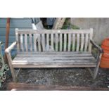 A teak bench with curve back, 58" wide x 33" high.