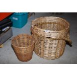 A wicker basket with rope handles and a wicker waste paper bin.