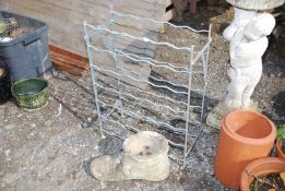 A galvanised wine rack and a concrete boot planter.