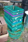 Ten plastic crates, and a length of garden hose.