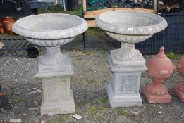 Two concrete Urns on plinths, 33" high.