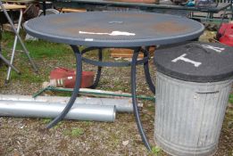 A metal mesh top round table with hole for parasol.