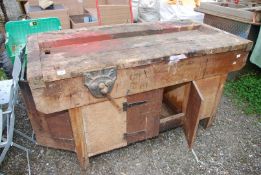 A wooden workshop bench (5' x 30" x 33" high) with lower cupboards and Carpenters vices.