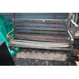 A garden bench with cast iron ends having lion head details (in need of restoration),