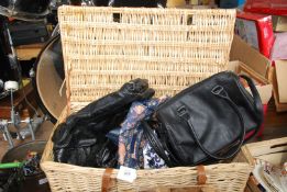 A wicker basket full of Ladies handbags.