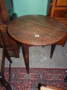 A peg-joyned Georgian Oak Cricket Table standing on tapering legs, the circular top,