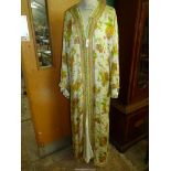 A vintage Moroccan silk Kaftan with satin under dress having orange and brown flower pattern.