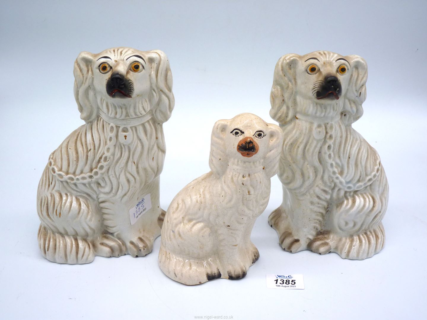 A pair of white Mantle spaniels and a smaller one, 9" and 7" tall.