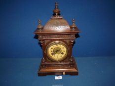 A wooden cased Mantle clock having Arabic numerals and finials to the top, a/f.