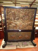 An ebonised hardwood chinoisiere Firescreen decorated with carved and gilded scenes of travellers