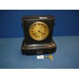 A small black slate Mantle clock having brass coloured face, Roman numerals, two chimes,