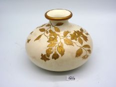 A squat shaped Wedgwood vase in cream, matt ground, with gold detail of foliage,