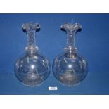 A pair of antique clear glass mantle vases with facet cut detail to the long slim necks with flared