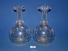 A pair of antique clear glass mantle vases with facet cut detail to the long slim necks with flared