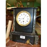 A black slate Mantle clock, some damage to top, having white enamel face with Roman numerals,