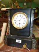 A black slate Mantle clock, some damage to top, having white enamel face with Roman numerals,