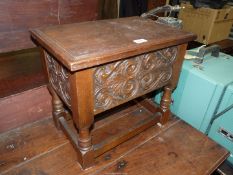 An Oak Workbox having a scrolling foliage carved front and sides and standing on turned legs united