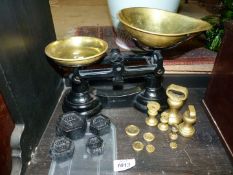 A pair of vintage brass kitchen scales with weights.