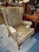 A Wing Fireside Chair for re-upholstery standing on brief cabriole front legs.