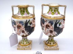 A pair of urn shaped Capo di Monte style Cherub vases with gilt colour square bases and raised