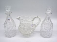 A pair of glass decanters and a cut glass water jug.