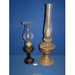 Two oil lamps, one glass with fluted rim and the other brass.