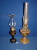 Two oil lamps, one glass with fluted rim and the other brass.