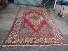 A large bordered, patterned and fringed Carpet, red,