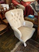 A beige Dralon upholstered button-back Armchair standing on turned front legs.