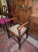 An Oak open armed Elbow Chair having turned front legs, stretcher and arm supports,