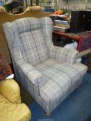 An attractive and comfortable Wing Fireside Chair upholstered in grey check pattern fabric and