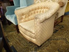 An early 20th century buttoned back Tub Armchair upholstered in beige fabric with repeated small